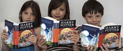 Three kids reading Harry Potter Three kids reading Harry Potter